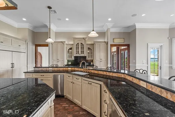 a large kitchen with a large center island and stainless steel appliances