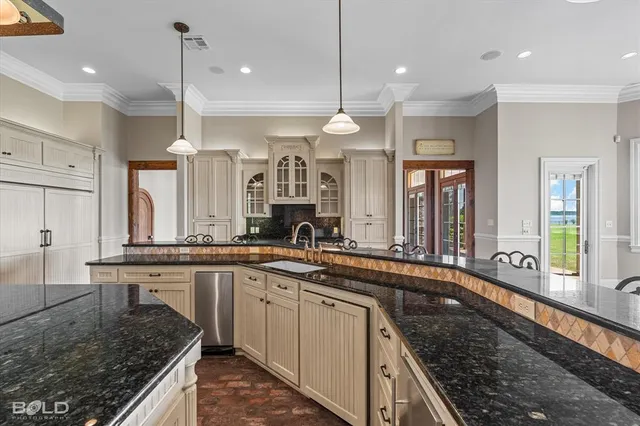 a large kitchen with a large center island and stainless steel appliances