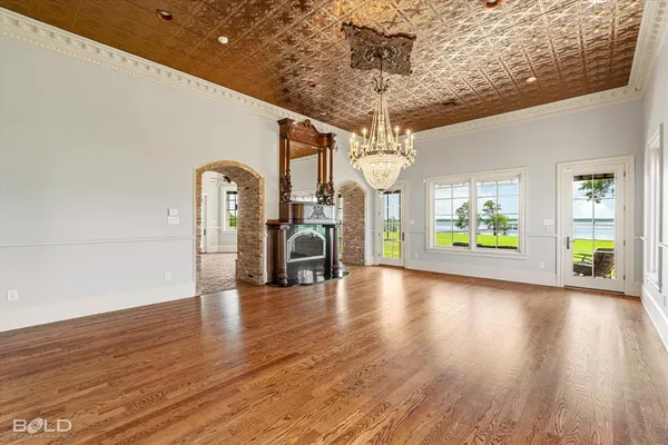 a view of a room with wooden floor a ceiling fan and windows