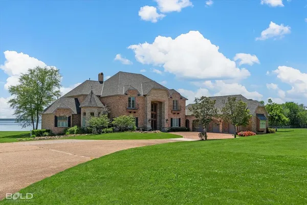 a front view of a house with a yard and trees