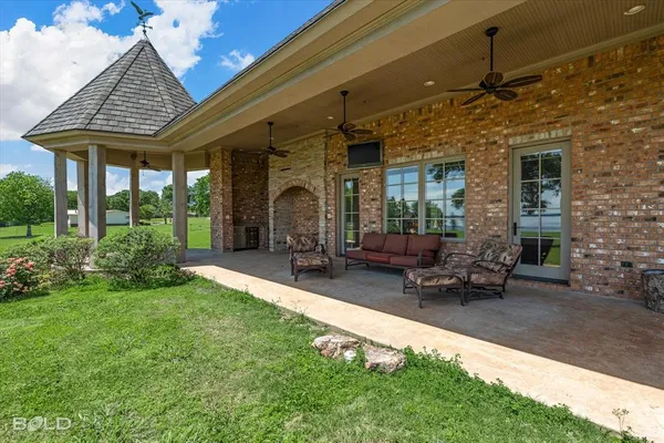 a patio with couches table and chairs with plants