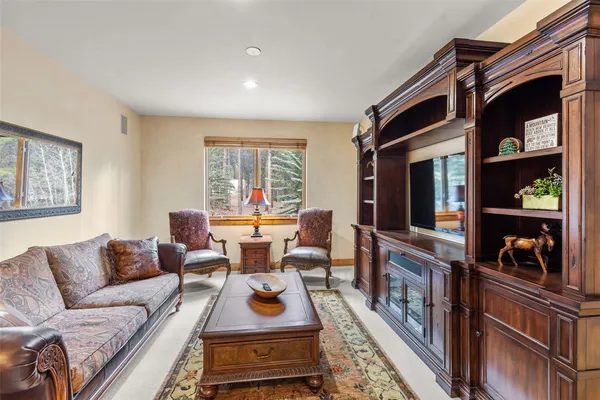 a living room with furniture a rug and a flat screen tv
