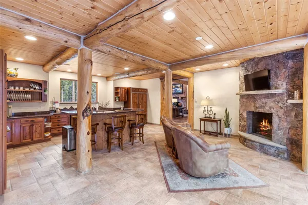 a living room with lots of chairs and kitchen view