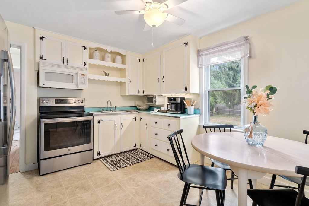 2 Westbrook Circle Worcester, MA 01602 - Photo 7 of 17 a white kitchen with stainless steel appliances a white table chairs and a window