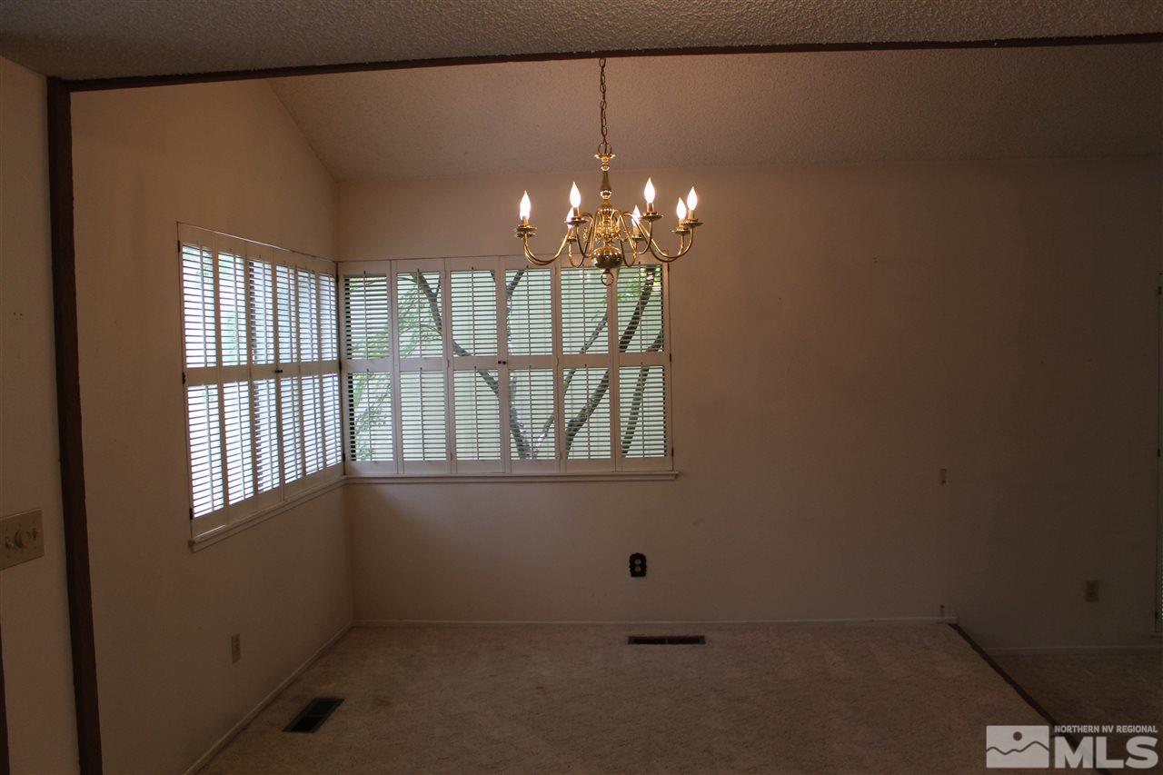 654 West Riverview Circle, Unit 654 Reno, NV 89509 - Photo 12 of 17 en empty room with windows and chandelier
