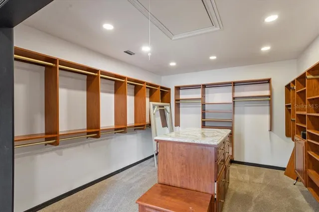 a view of an empty room with wooden floor and a ceiling fan