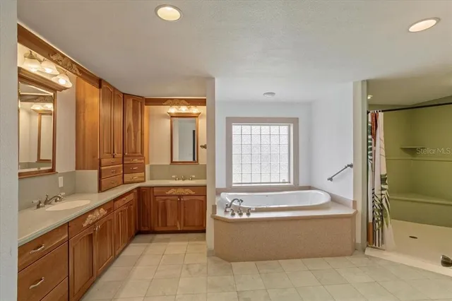 a view of an empty room with wooden floor and a kitchen