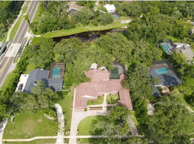 an aerial view of residential houses with outdoor space and trees