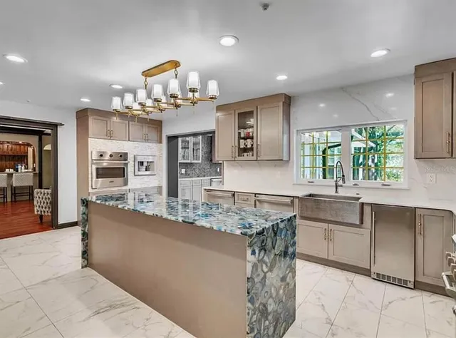 a large kitchen with kitchen island granite countertop a large window