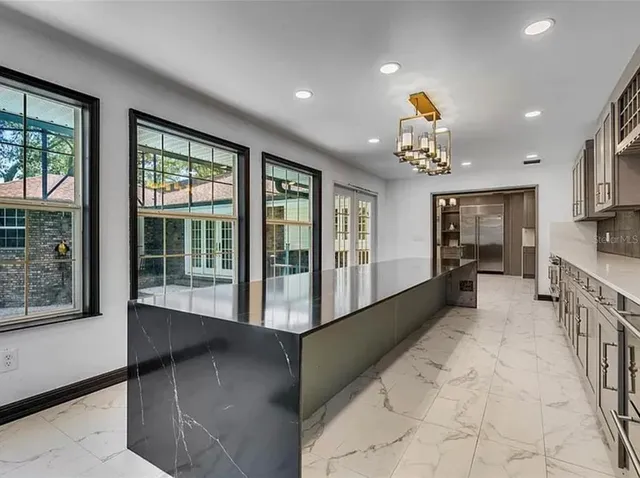 a hallway with white cabinets and wooden floor