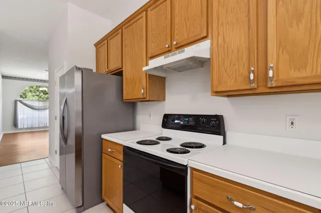 a kitchen with stainless steel appliances a stove a refrigerator and cabinets