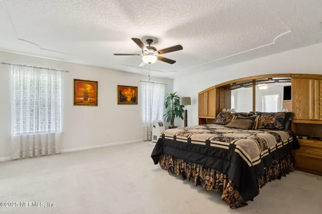 a bedroom with a large bed and a chandelier