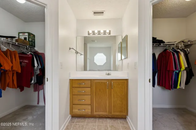 an empty room with a chandelier fan and windows