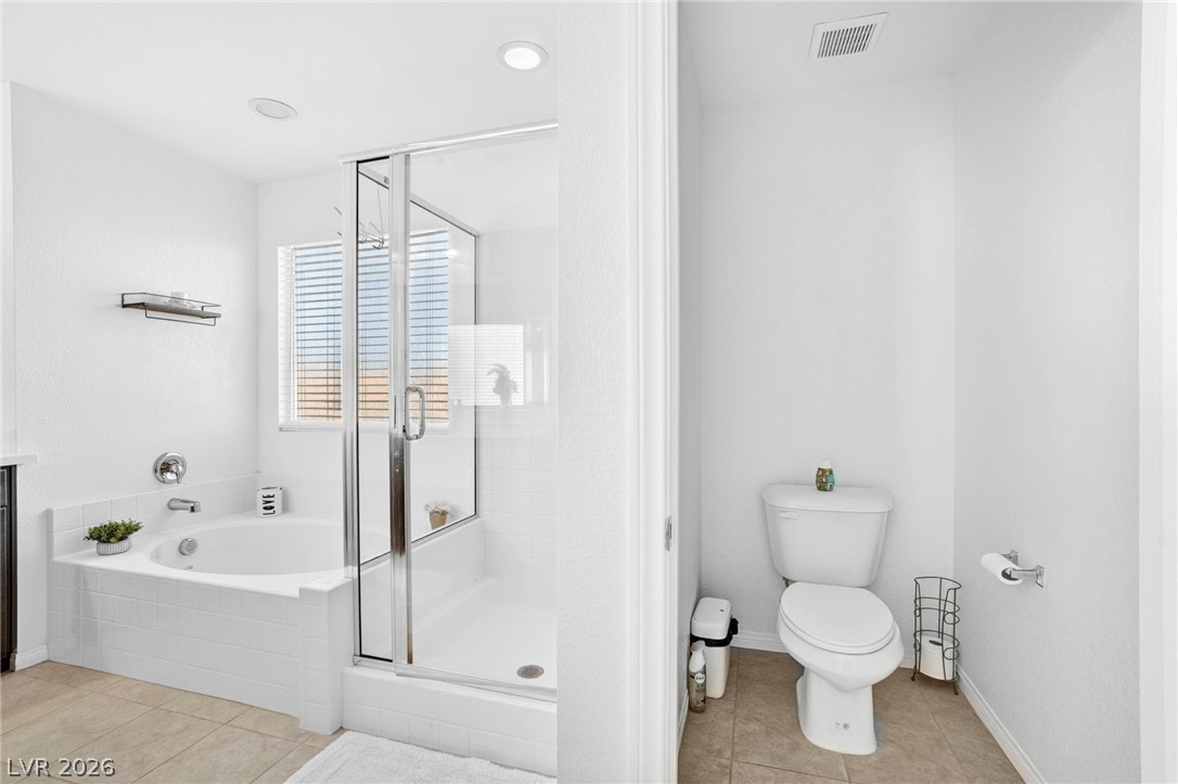 6281 Angora Peak Lane Las Vegas, NV 89115 - Photo 20 of 34 Luxurious bath with a deep soaking tub and a sleek glass-enclosed shower.