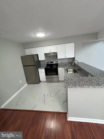 a view of kitchen with granite countertop cabinets and wooden floor