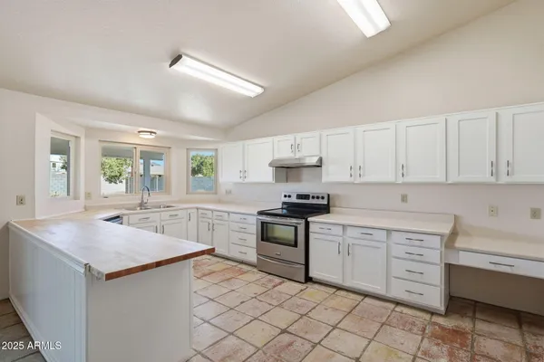 a kitchen with granite countertop cabinets stainless steel appliances and a counter space