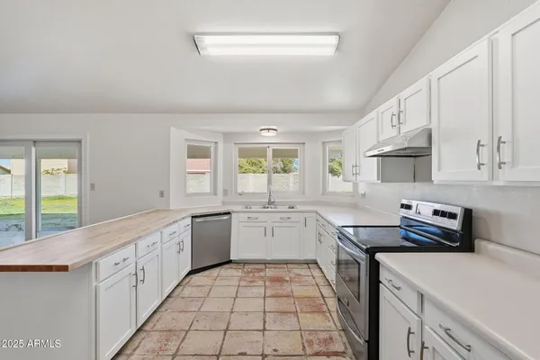 a kitchen with a sink stove and cabinets