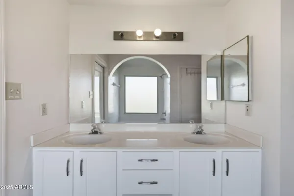 a bathroom with a double vanity sink and a mirror