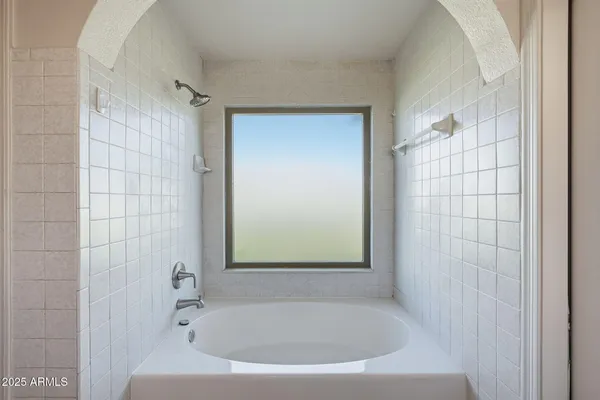 a white bath tub sitting in a bathroom next to a shower