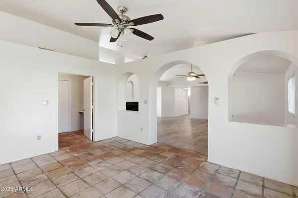 a view of a livingroom with a ceiling fan and entryway