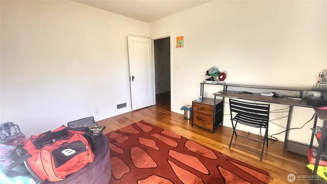 a bedroom with a bed and wooden floor