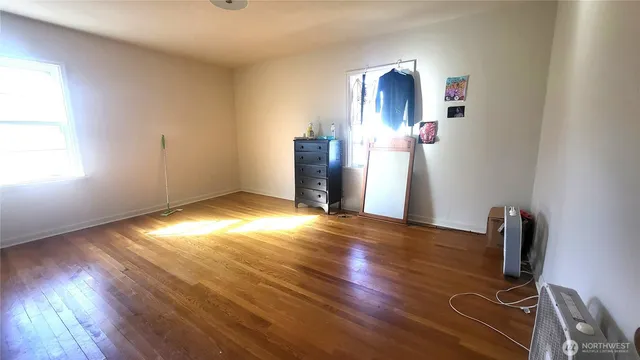 a view of empty room with wooden floor
