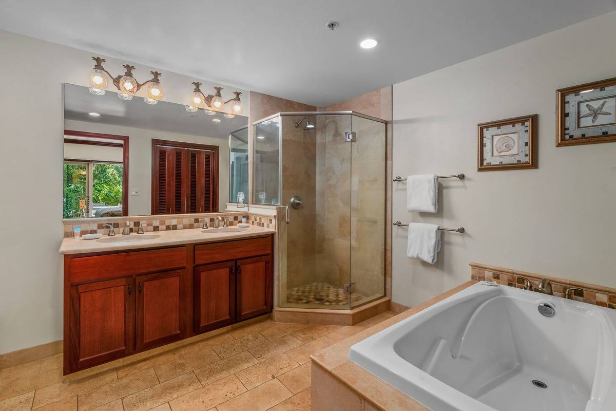 4-820 Kuhio Highway, Unit E103 Kapaa, HI 96746 - Photo 12 of 24 a bathroom with a tub a sink shower and mirror
