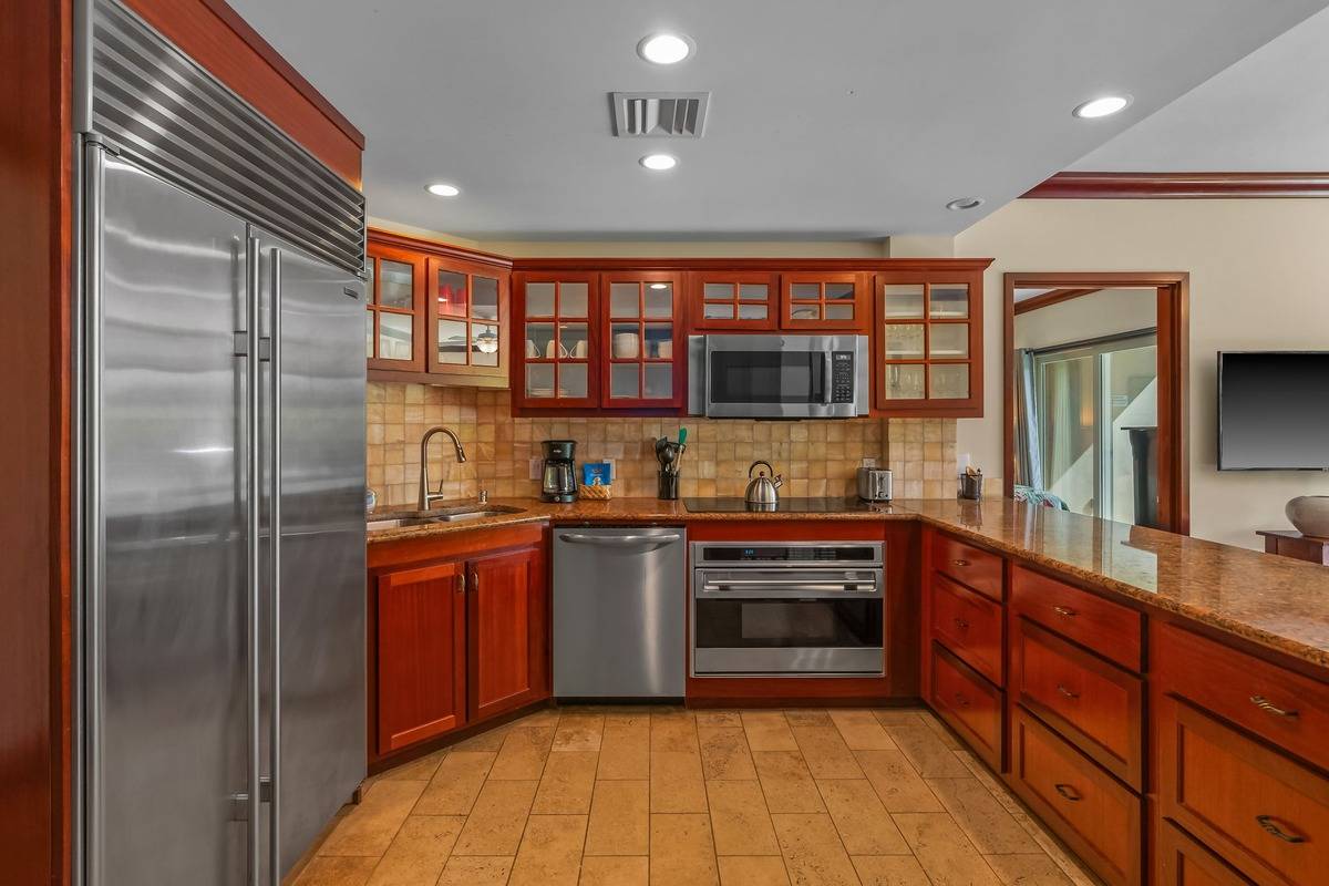 4-820 Kuhio Highway, Unit E103 Kapaa, HI 96746 - Photo 2 of 24 a kitchen with stainless steel appliances granite countertop a refrigerator and a sink