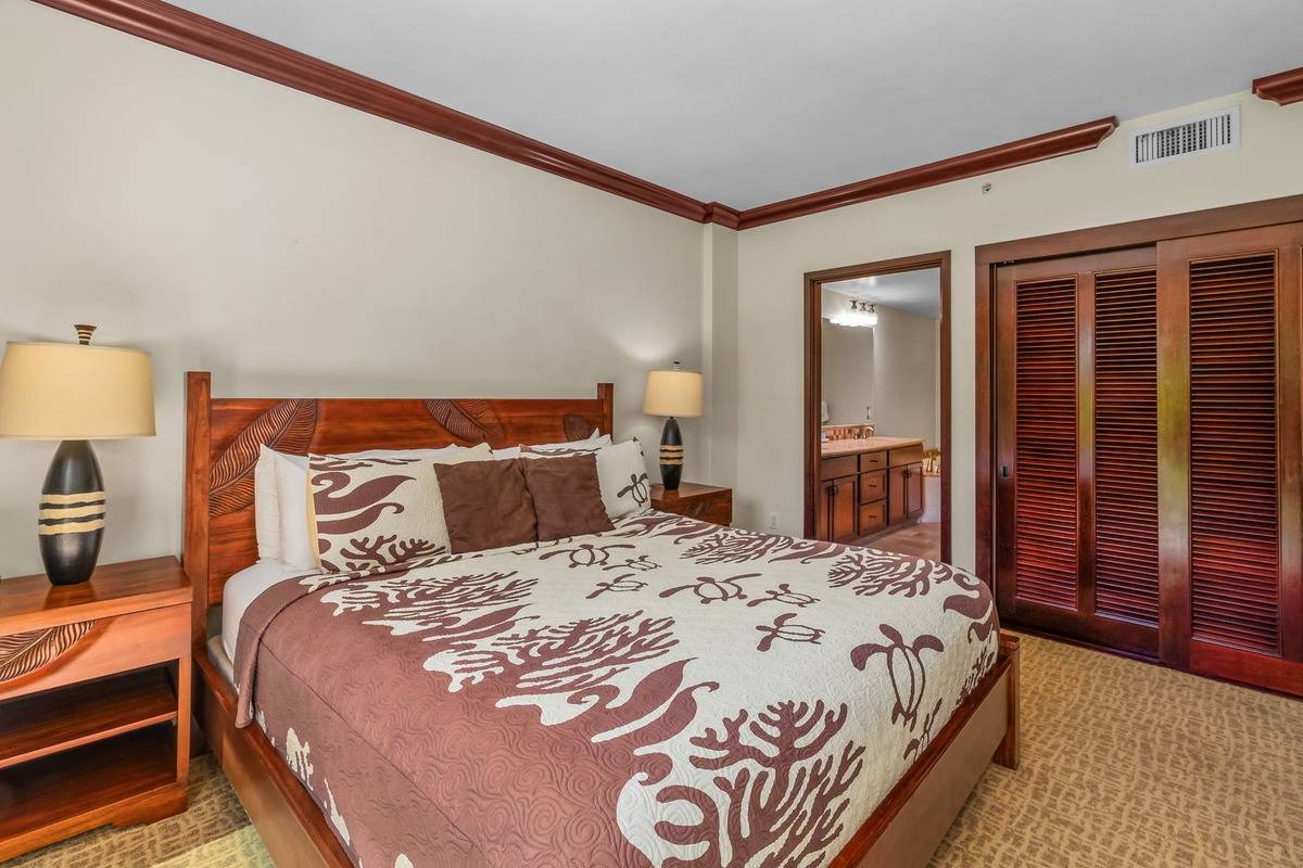 4-820 Kuhio Highway, Unit E103 Kapaa, HI 96746 - Photo 7 of 24 a bedroom with a bed and wooden floor