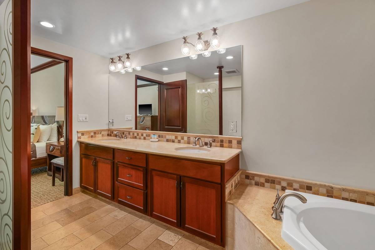 4-820 Kuhio Highway, Unit E103 Kapaa, HI 96746 - Photo 9 of 24 a bathroom with a sink double vanity and a large mirror