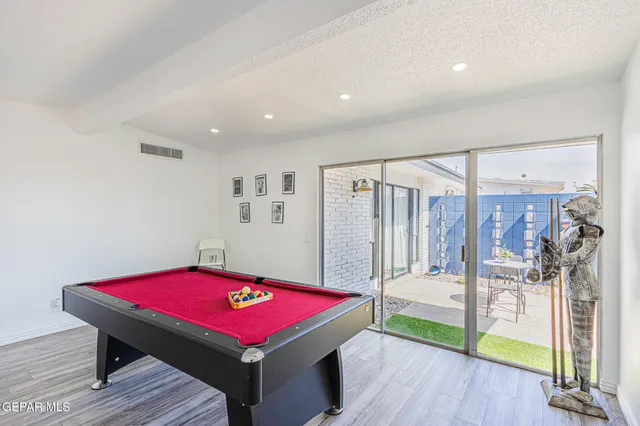 a room with pool table and glass windows