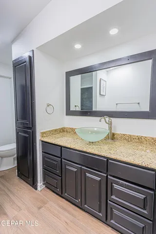 a bathroom with a granite countertop sink and a mirror