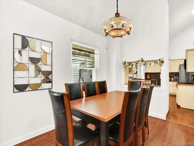 a view of a dining room with furniture a chandelier and wooden floor