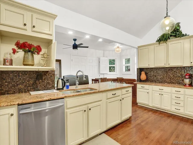 a kitchen with a sink dishwasher and white cabinets