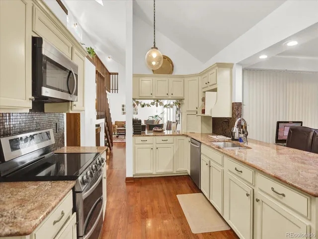 a kitchen with stainless steel appliances granite countertop a sink stove and refrigerator