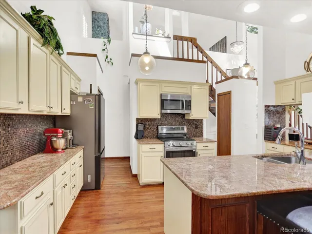 a kitchen with stainless steel appliances granite countertop a sink a stove and cabinets