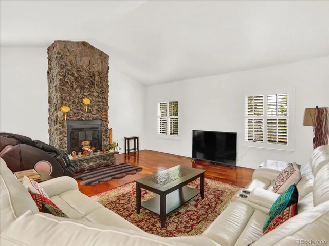 a living room with furniture a flat screen tv and a window