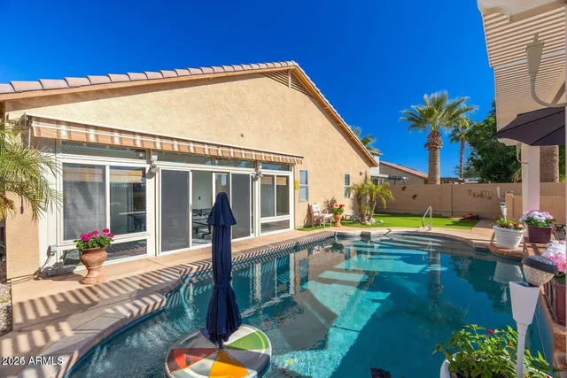 a view of a house with swimming pool and sitting area