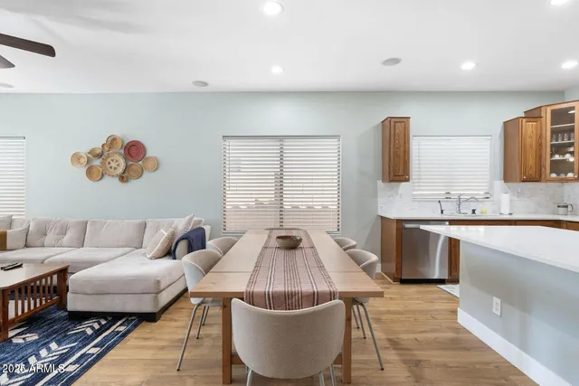 a kitchen with stainless steel appliances granite countertop a table chairs sink refrigerator and stove