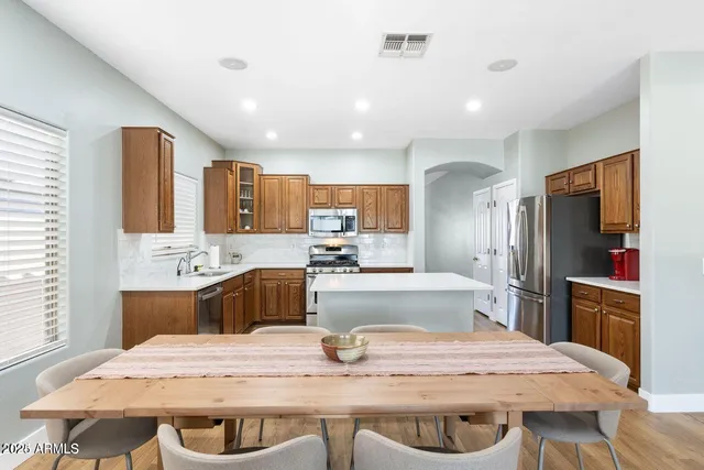 a living room with furniture kitchen view and a chandelier