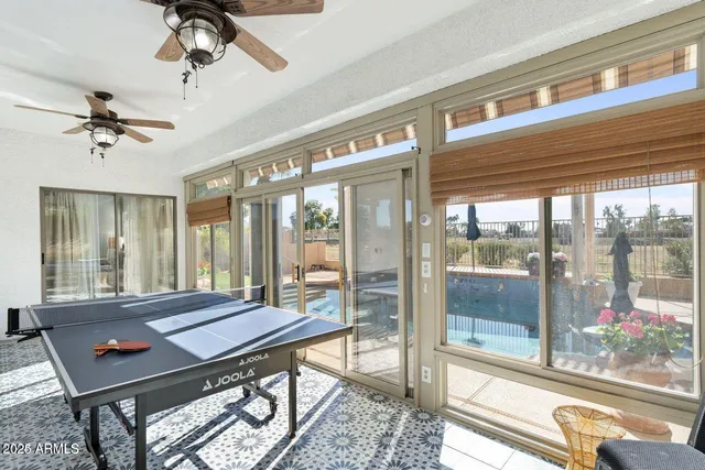 a swimming pool view with a seating space and a ocean view in the background
