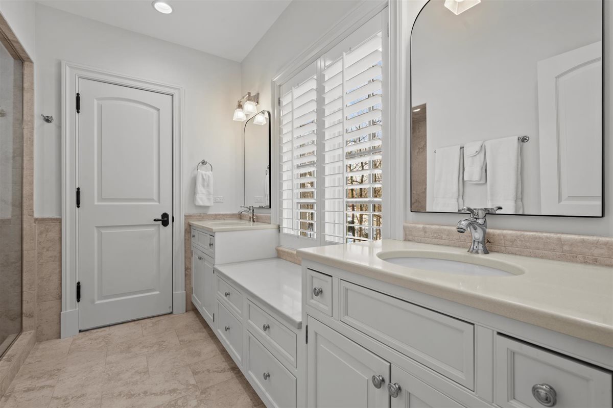 745 East Woodland Road Lake Forest, IL 60045 - Photo 51 of 77 a bathroom with a double vanity sink a mirror and a bathtub