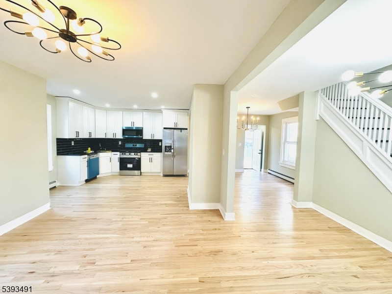 1222 West 3rd Street Plainfield, NJ 07063 - Photo 16 of 50 a view of a kitchen with kitchen island wooden floor center island and stainless steel appliances