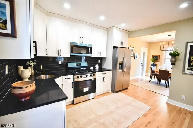 a kitchen with stainless steel appliances granite countertop a refrigerator stove microwave and sink