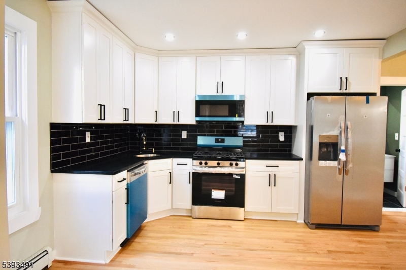 1222 West 3rd Street Plainfield, NJ 07063 - Photo 19 of 50 a kitchen with stainless steel appliances a refrigerator sink and white cabinets