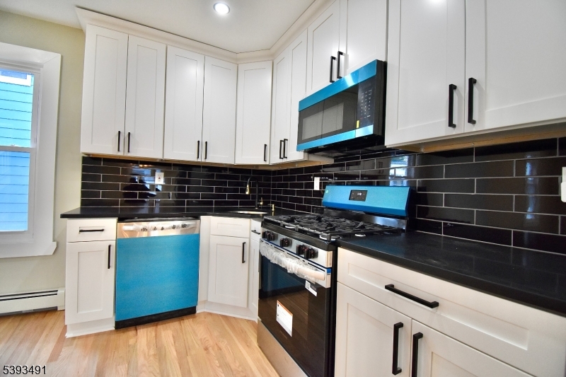 1222 West 3rd Street Plainfield, NJ 07063 - Photo 20 of 50 a kitchen with stainless steel appliances a stove a microwave and cabinets