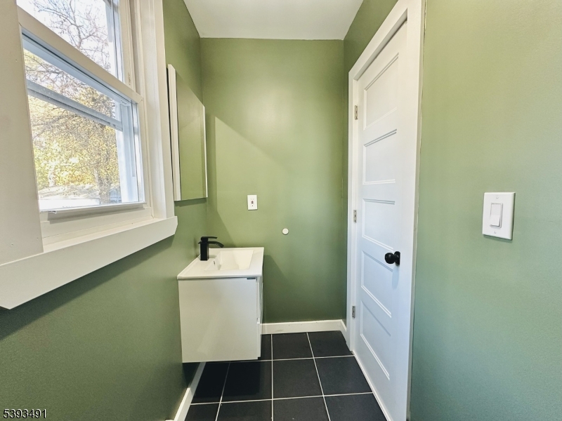 1222 West 3rd Street Plainfield, NJ 07063 - Photo 26 of 50 a bathroom with a sink a mirror and a window
