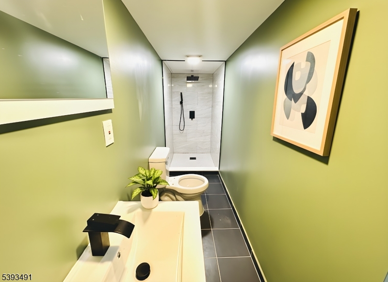 1222 West 3rd Street Plainfield, NJ 07063 - Photo 41 of 50 a bathroom with a sink and mirror with bathtub