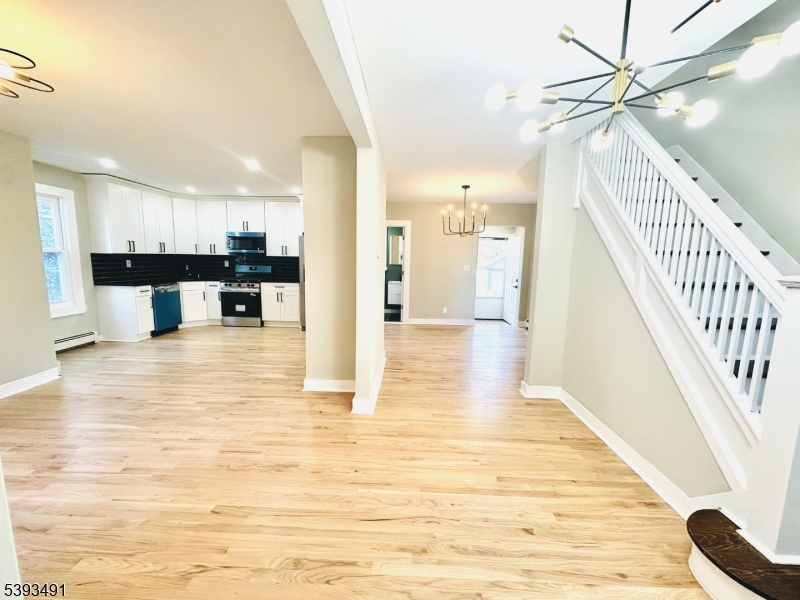 1222 West 3rd Street Plainfield, NJ 07063 - Photo 8 of 50 a view of a living room with kitchen view and wooden floor