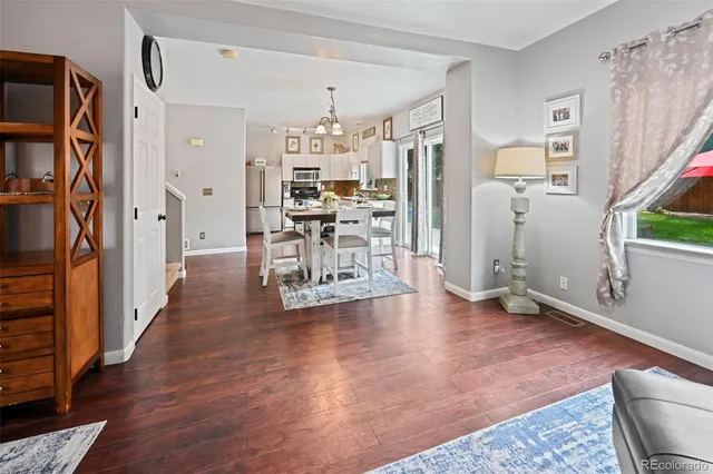 a view of a livingroom with wooden floor and furniture